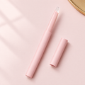 Clear twist-up lip liner pen with blush pink barrel and transparent tip, cap beside it, on a soft blush pink background